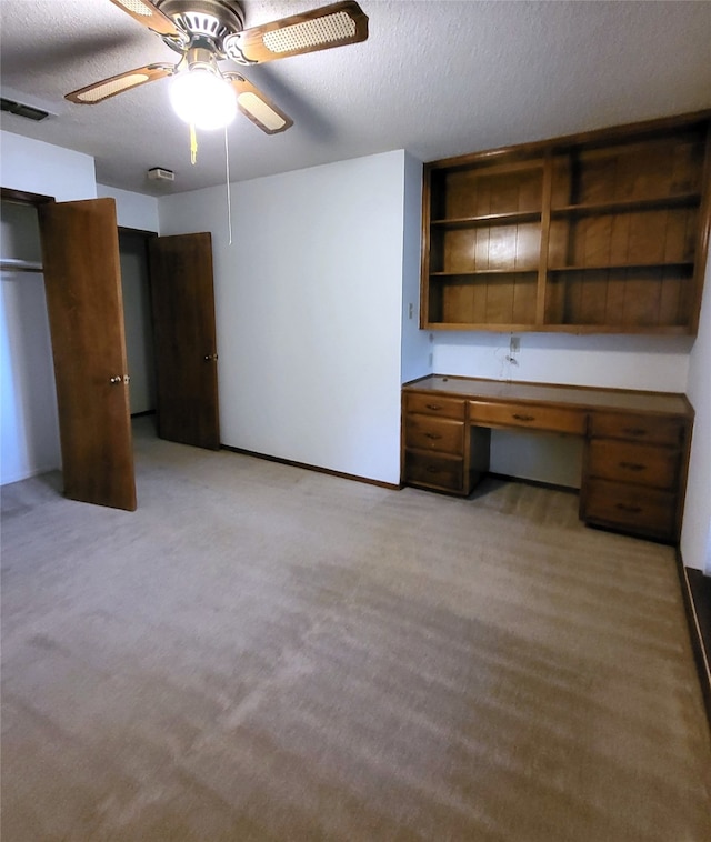 697 Highland Crest Dr, Hurst, TX 76054 - unfurnished office with a textured ceiling, light colored carpet, built in desk, and ceiling fan