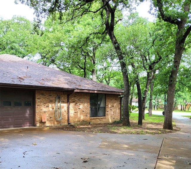 697 Highland Crest Dr, Hurst, TX 76054 - view of front of house featuring driveway, a garage, brick siding, and roof with shingles