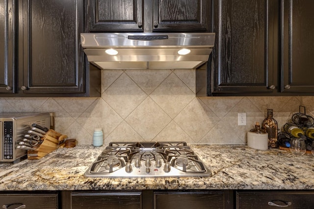 1970 Lake Forest Dr, Rockwall, TX 75087 - kitchen with range hood, stainless steel gas stovetop, dark brown cabinetry, and backsplash