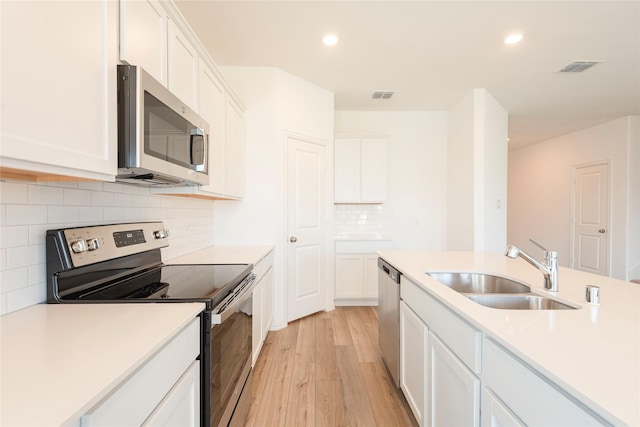 219 Autumn Sage Ln, Princeton, TX 75407 - kitchen featuring stainless steel appliances, light wood finished floors, white cabinets, light countertops, and recessed lighting