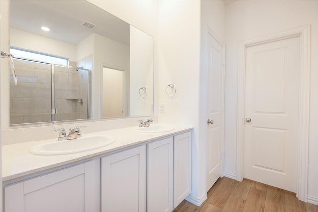 219 Autumn Sage Ln, Princeton, TX 75407 - bathroom featuring double vanity, wood finished floors, and a tile shower