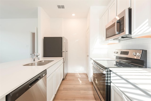 219 Autumn Sage Ln, Princeton, TX 75407 - kitchen with stainless steel appliances, light countertops, white cabinetry, light wood-style floors, and recessed lighting