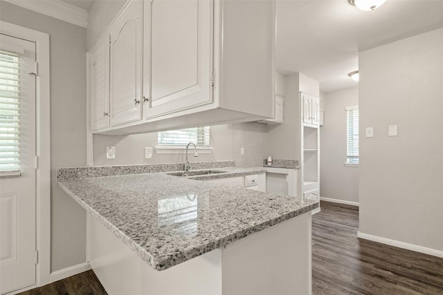 2405 Patricia Ln, Garland, TX 75041 - kitchen featuring a peninsula, white cabinets, light stone countertops, dark wood finished floors, and plenty of natural light