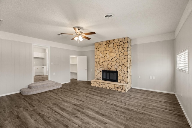 2405 Patricia Ln, Garland, TX 75041 - unfurnished living room with wood finished floors, a ceiling fan, a textured ceiling, and a fireplace