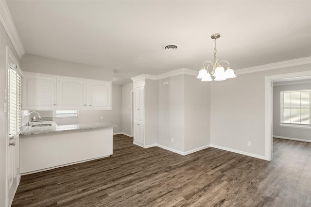 2405 Patricia Ln, Garland, TX 75041 - kitchen featuring dark wood-style floors, white cabinets, ornamental molding, a chandelier, and hanging light fixtures