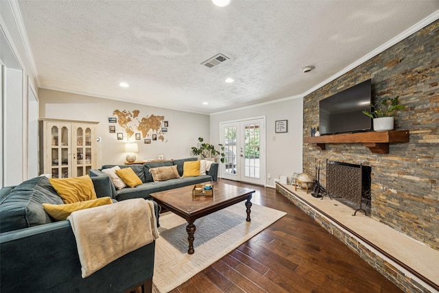 2924 Whitemarsh Cir, Richardson, TX 75080 - living area with ornamental molding, wood-type flooring, a textured ceiling, a stone fireplace, and french doors