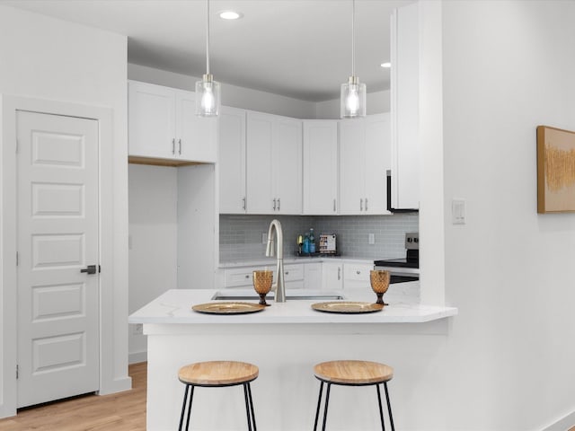 5223 Willie St, Fort Worth, TX 76105 - kitchen with stainless steel range with electric cooktop, a peninsula, white cabinets, a kitchen bar, and recessed lighting