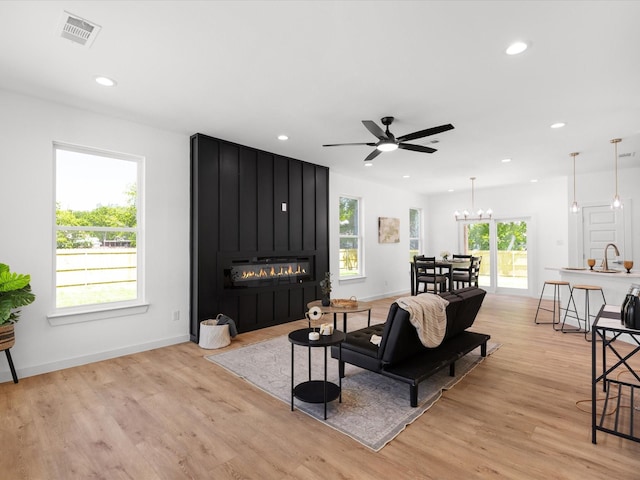 5223 Willie St, Fort Worth, TX 76105 - living area with a fireplace, light wood-style floors, a ceiling fan, recessed lighting, and a chandelier