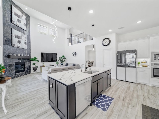 412 Navo Rd, Little Elm, TX 75068 - kitchen featuring dishwashing machine, stainless steel oven, white refrigerator, white cabinets, and a large fireplace