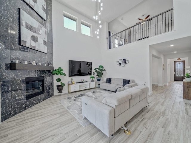 412 Navo Rd, Little Elm, TX 75068 - living room with a premium fireplace, a towering ceiling, ceiling fan, and wood finished floors