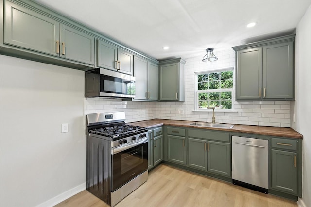 736 Wilson St, Denton, TX 76205 - kitchen featuring stainless steel appliances, butcher block counters, light wood-style flooring, backsplash, and recessed lighting