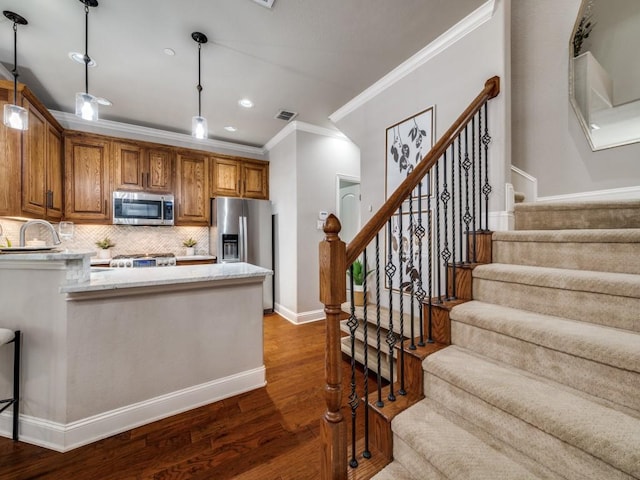 1901 Desoto Dr, Mckinney, TX 75072 - kitchen with appliances with stainless steel finishes, crown molding, dark wood-style flooring, decorative light fixtures, and brown cabinets