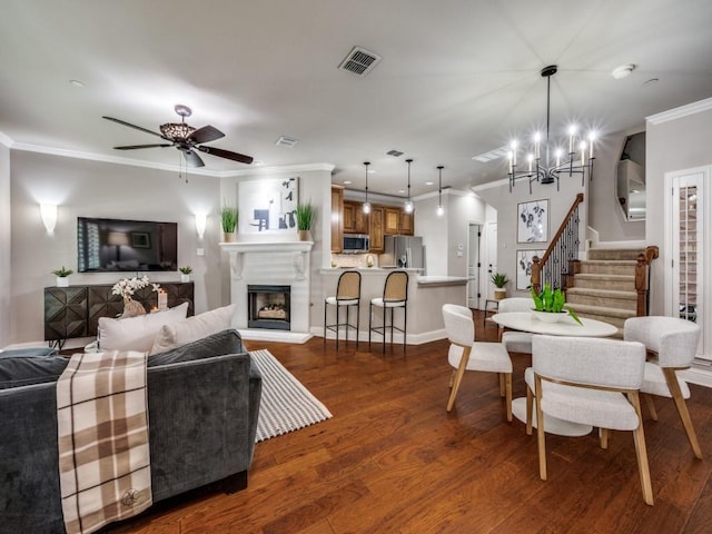 1901 Desoto Dr, Mckinney, TX 75072 - living area with stairway, ornamental molding, a chandelier, dark wood-style floors, and a fireplace with raised hearth