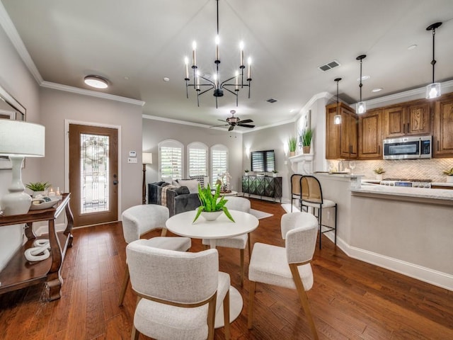 1901 Desoto Dr, Mckinney, TX 75072 - dining room with crown molding, dark wood-type flooring, a ceiling fan, and a chandelier