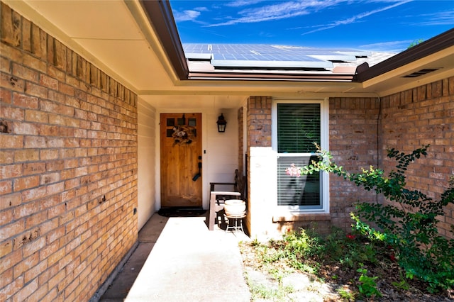 7612 Creekmoore Dr, Fort Worth, TX 76133 - doorway to property with roof mounted solar panels and brick siding