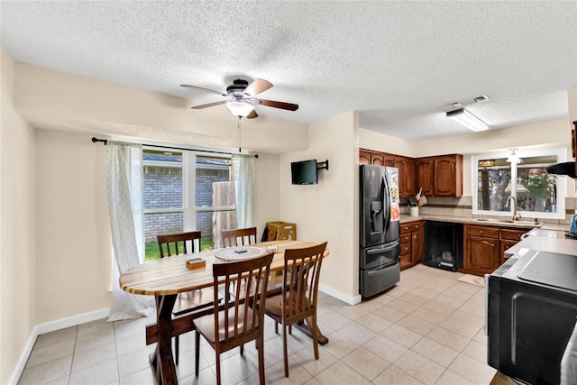 7612 Creekmoore Dr, Fort Worth, TX 76133 - kitchen with refrigerator with ice dispenser, ceiling fan, black dishwasher, light countertops, and light tile patterned floors