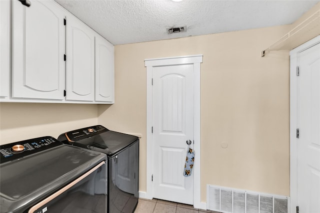 7612 Creekmoore Dr, Fort Worth, TX 76133 - laundry area featuring independent washer and dryer, cabinet space, light tile patterned floors, and a textured ceiling