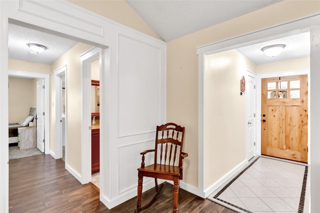 7612 Creekmoore Dr, Fort Worth, TX 76133 - entryway featuring wood finished floors, vaulted ceiling, and a textured ceiling