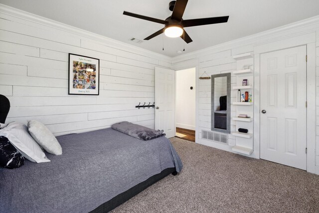 1212 Chandler Cir, Prosper, TX 75078 - carpeted bedroom featuring ornamental molding, a ceiling fan, and wooden walls