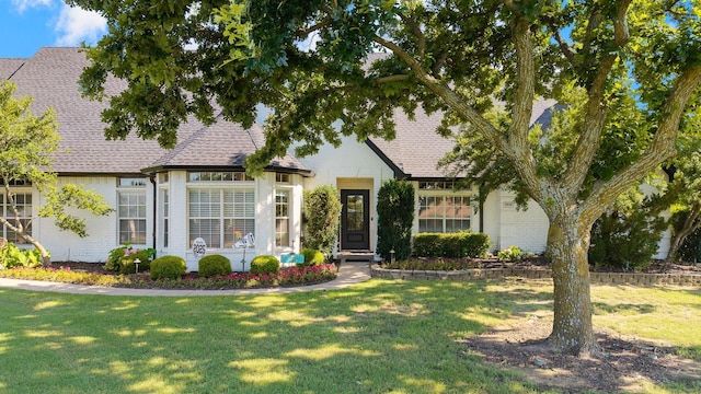 1212 Chandler Cir, Prosper, TX 75078 - tudor home with brick siding, a front yard, and a shingled roof