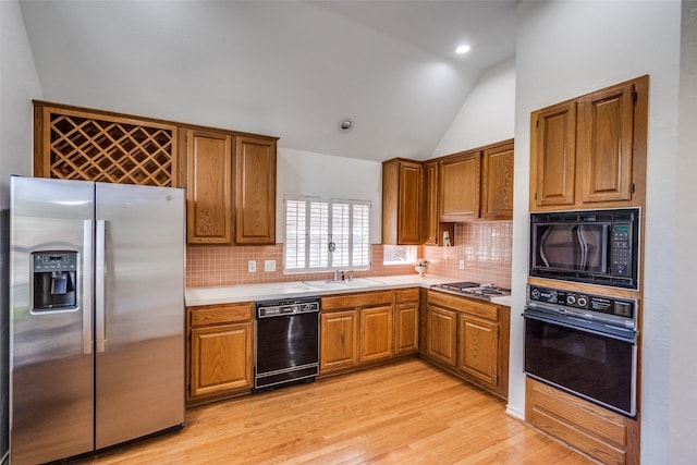 1908 Vantage Dr, Plano, TX 75075 - kitchen with black appliances, lofted ceiling, light wood finished floors, brown cabinetry, and light countertops