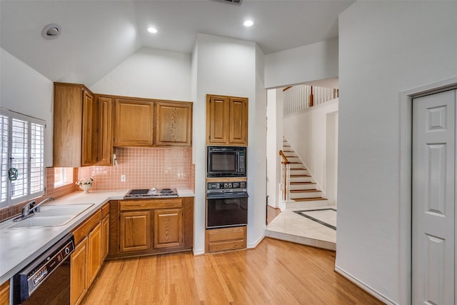 1908 Vantage Dr, Plano, TX 75075 - kitchen featuring black appliances, light wood-style flooring, backsplash, brown cabinetry, and vaulted ceiling