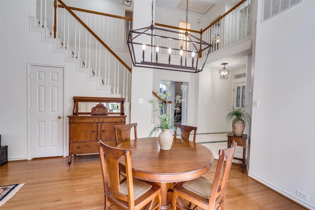 1908 Vantage Dr, Plano, TX 75075 - dining area featuring a towering ceiling, light wood-style flooring, and a chandelier