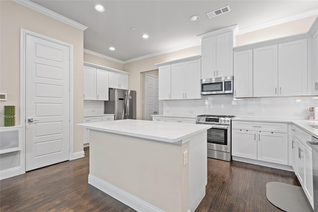8538 Church St, Frisco, TX 75034 - kitchen with stainless steel appliances, a center island, recessed lighting, crown molding, and white cabinets