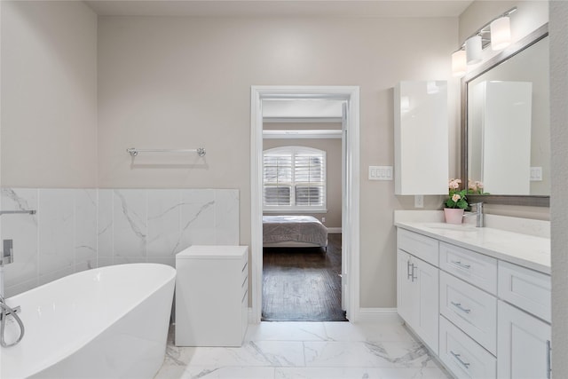 8538 Church St, Frisco, TX 75034 - ensuite bathroom with vanity, a freestanding tub, marble finish floors, and tile walls