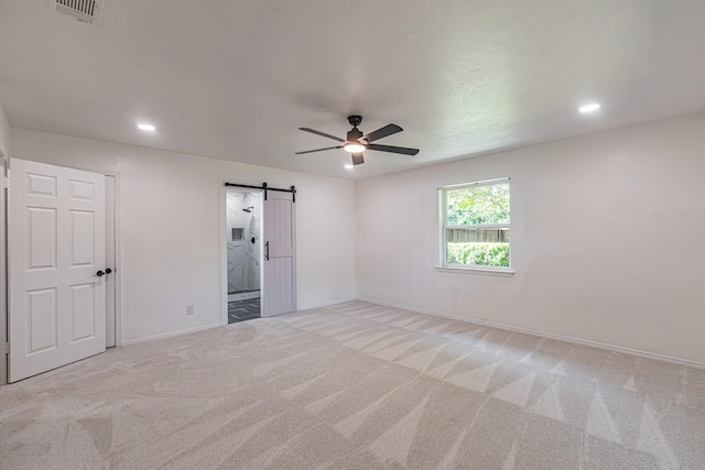 1517 Amherst Dr, Plano, TX 75075 - unfurnished bedroom with light colored carpet, a barn door, recessed lighting, ensuite bath, and ceiling fan