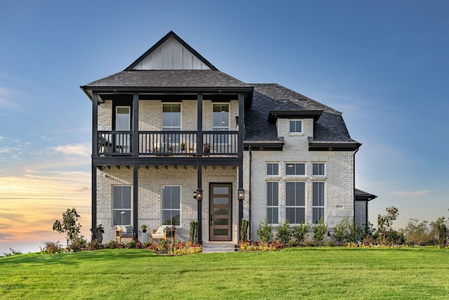 2718 Sunrise Dr, Rowlett, TX 75089 - view of front of property featuring a balcony, brick siding, a front lawn, and board and batten siding