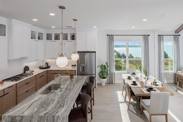 2718 Sunrise Dr, Rowlett, TX 75089 - kitchen with appliances with stainless steel finishes, glass insert cabinets, backsplash, a breakfast bar, and recessed lighting