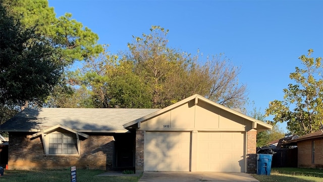 5410 Kings Manor Dr, Lake Dallas, TX 75065 - view of front of property featuring an attached garage, brick siding, and concrete driveway