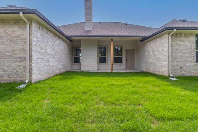 458 Jim Walters Dr, Runaway Bay, TX 76426 - rear view of house featuring a chimney, a yard, brick siding, and roof with shingles