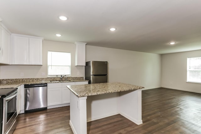 2906 Emma Ln, Mabank, TX 75147 - kitchen with stainless steel appliances, a kitchen island, white cabinets, recessed lighting, and light stone countertops