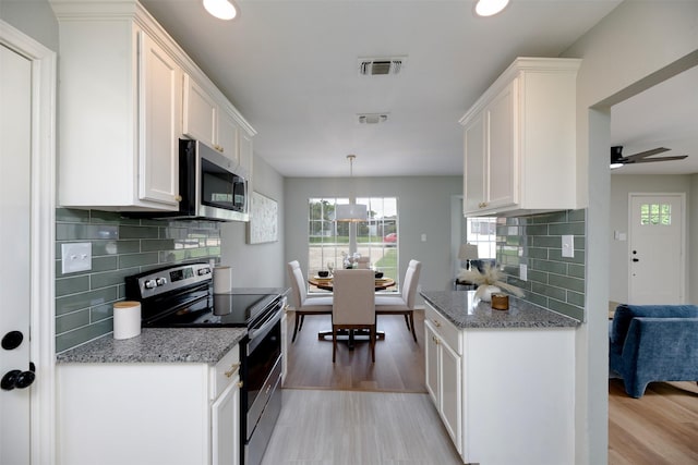4817 Springsong Ln, Arlington, TX 76017 - kitchen featuring stainless steel appliances, white cabinets, decorative backsplash, light stone counters, and light wood-type flooring