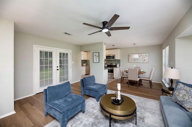 4817 Springsong Ln, Arlington, TX 76017 - living room with light wood finished floors, french doors, and a ceiling fan