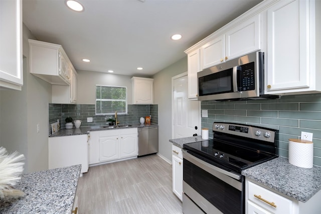 4817 Springsong Ln, Arlington, TX 76017 - kitchen featuring appliances with stainless steel finishes, white cabinetry, light stone counters, decorative backsplash, and recessed lighting