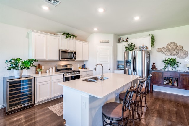 595 Yucca Ct, Princeton, TX 75407 - kitchen featuring stainless steel appliances, wine cooler, dark wood finished floors, tasteful backsplash, and an island with sink