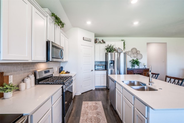595 Yucca Ct, Princeton, TX 75407 - kitchen with stainless steel appliances, dark wood-style floors, backsplash, white cabinets, and a center island with sink