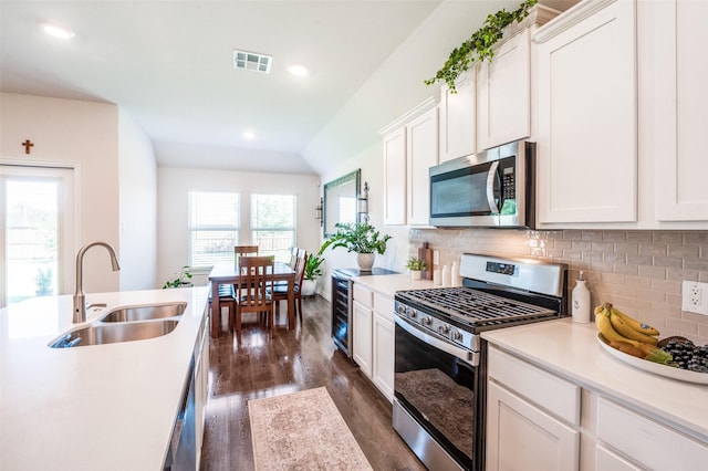 595 Yucca Ct, Princeton, TX 75407 - kitchen featuring stainless steel appliances, dark wood-style flooring, light countertops, decorative backsplash, and white cabinets