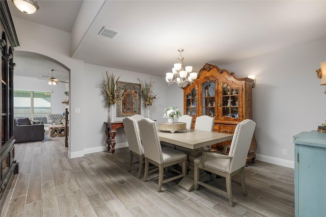 324 Roscoe Dr, Fate, TX 75087 - dining area with light wood-type flooring, a chandelier, arched walkways, and ceiling fan