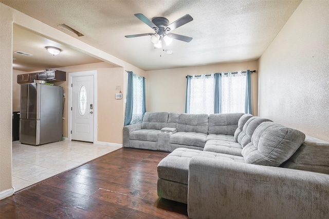 3624 Hardeman St, Fort Worth, TX 76119 - living area with light wood-type flooring, ceiling fan, and a textured ceiling