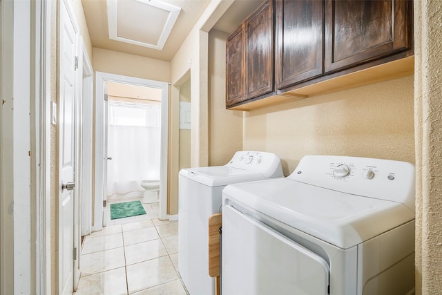 3624 Hardeman St, Fort Worth, TX 76119 - washroom featuring washing machine and dryer, cabinet space, and light tile patterned floors