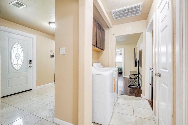 3624 Hardeman St, Fort Worth, TX 76119 - laundry room with light tile patterned floors, washer and clothes dryer, and cabinet space
