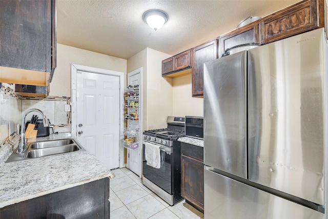 3624 Hardeman St, Fort Worth, TX 76119 - kitchen with appliances with stainless steel finishes, light countertops, light tile patterned flooring, dark brown cabinetry, and a textured ceiling