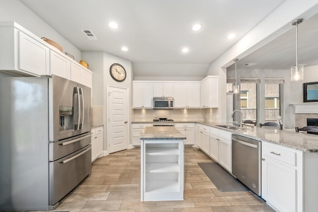 705 Rio Concho Trl, Mckinney, TX 75071 - kitchen featuring stainless steel appliances, open shelves, a peninsula, recessed lighting, and light stone counters