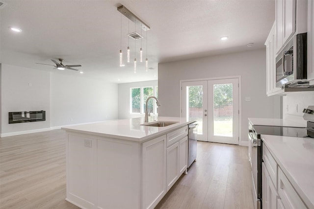 507 S 4th St, Grandview, TX 76050 - kitchen with appliances with stainless steel finishes, light wood-style floors, french doors, white cabinetry, and recessed lighting