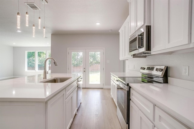 507 S 4th St, Grandview, TX 76050 - kitchen featuring stainless steel appliances, light countertops, light wood-style flooring, french doors, and recessed lighting