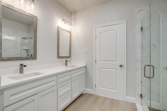 507 S 4th St, Grandview, TX 76050 - bathroom featuring a marble finish shower, double vanity, and wood finished floors